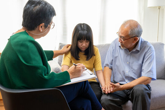 Parents telling the psychologist about family or child problems. Depressed girl and her parent or grandpa having session with psychiatrist in clinic.
