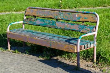 an old bench with stripped paint in the park