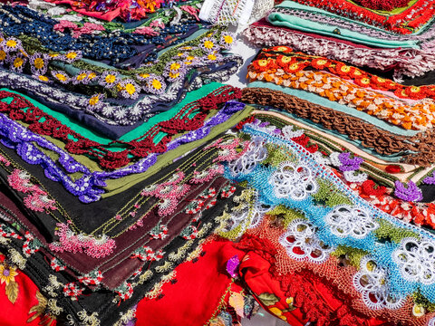 Needle lace headscarves with colorful border. Handmade tradition.  Many floral pattern and texture background with copy space. Beautiful stitches in details. Woman in Turkey economy. Religious sign