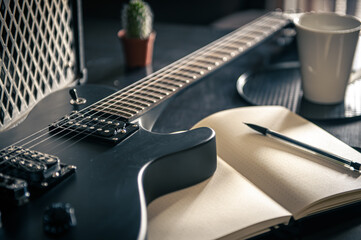 Fototapeta premium Close-up, electric guitar and notepad, concept of musical creativity.