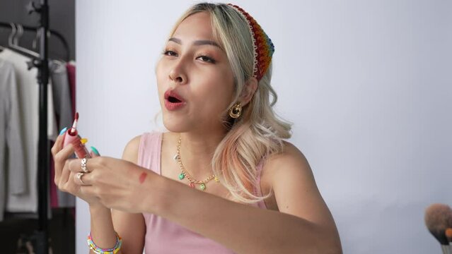 Young beautiful Asian woman and professional beauty make up artist vlogger or blogger recording makeup tutorial to share on website or social media. Business online influencer on social media concept.
