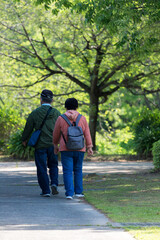 Fototapeta na wymiar 初夏の公園で散歩している中年夫婦の姿