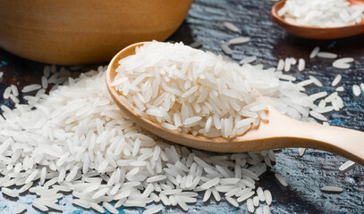 Organic raw white rice in wooden spoon.