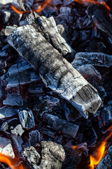 a fire made of logs with a bright flame at a camping while cooking