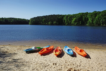 Colorful kayaks on the shore of Lake Johnson, a popular city park in Raleigh NC - obrazy, fototapety, plakaty