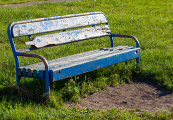 an old bench with stripped paint in the park