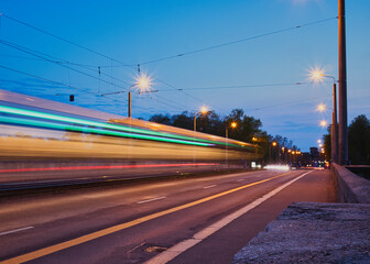 Fototapeta na wymiar Traffic Light auf der Jahnallee Brücke, Straßenbahn fährt vorbei, Nacht und beleuchtet, Leipzig, Deutschland
