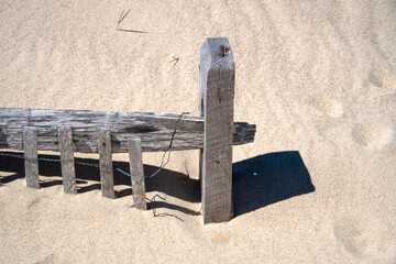 Fototapeta premium Cape Cod in springtime Close-up view of a fence buried in the sand