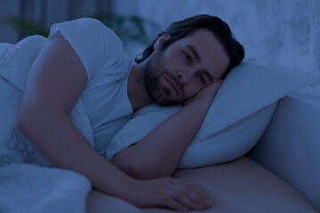 Depressed man cant sleep at night, laying in bed alone