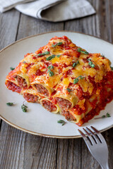 Cannelloni with meat, cheese, tomatoes and thyme. Italian cuisine.