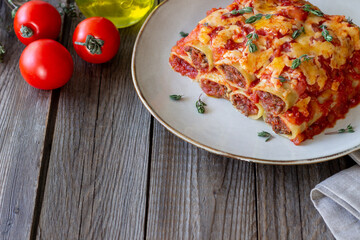 Cannelloni with meat, cheese, tomatoes and thyme. Italian cuisine.