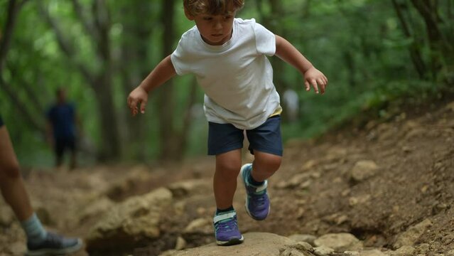 Little boy hiking outside in nature path child in green outdoors