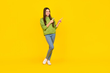 Fototapeta na wymiar Full body photo of young cheerful girl indicate fingers empty space promo select banner isolated over yellow color background