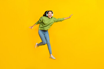 Fototapeta na wymiar Full size photo of young cheerful girl have fun jump fly meloman sound isolated over yellow color background