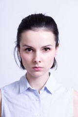 woman in a blue sleeveless office shirt, light background