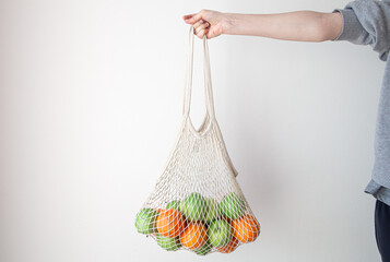 White string bag with fruits on a white background.