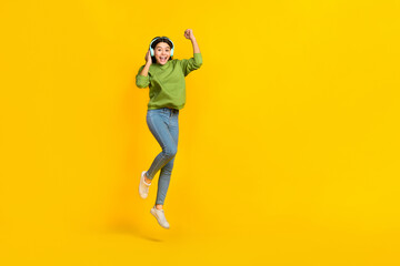 Fototapeta na wymiar Full length photo of young active girl celebrate luck success triumph jump up listen radio isolated over yellow color background