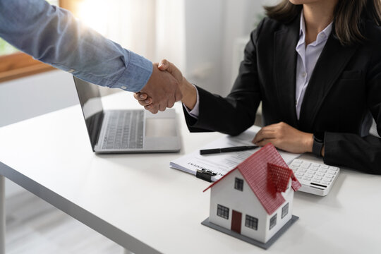 Real estate agents and customers shake hands to congratulate on signing a contract to buy a house with land and insurance, handshake and Good response concept