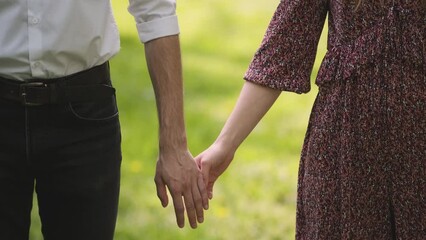 Hold on, hands, couple. Couple holding their hands on sun day. couple holding hand in the park. Couplesholding hand. Young couple in love walking in the park holding hand
