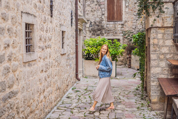 Woman tourist enjoying Colorful street in Old town of Kotor on a sunny day, Montenegro. Travel to Montenegro concept