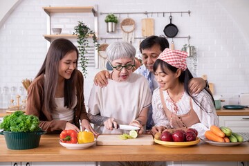 Family vegetarian is cooking together for holidays.Asian Parents and daughters are cutting...