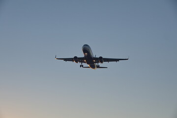 Fototapeta na wymiar Commercial jet flying, in silhouette, in the evening, in Fort Lauderdale, Florida, USA