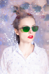 art portrait of a woman in green glasses with red lipstick on her lips in a white shirt