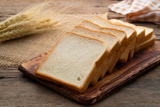 Sliced white bread on wooden board