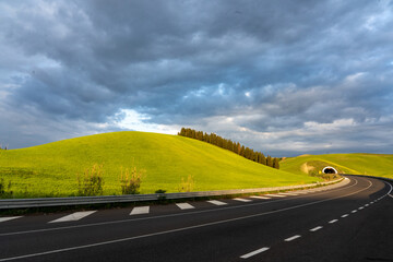 Strada asfaltata tra le verdi colline della Toscana 