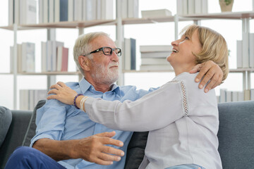 Obraz premium Happy senior couple family, caucasians mature, adult lover and retired man, woman embracing, hugging make romantic, empathy on sofa, couch at home together. Smile, husband and his wife lifestyle.