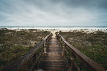 Fototapeta na wymiar Overcast moody cloudy day on the beach boardwalk Amelia Island, Florida