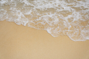 Fototapeta na wymiar beautiful soft ocean waves on sandy beach background