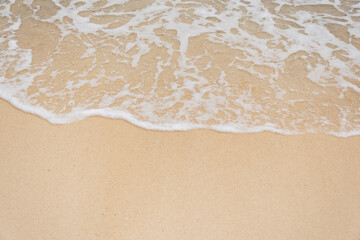 beautiful soft ocean waves on sandy beach background