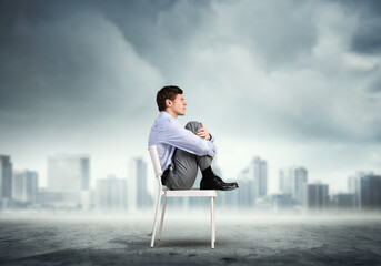 scared businessman on a chair