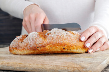 a fresh soft loaf of bread cut into pieces with a knife