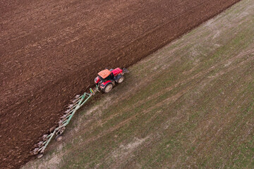 A tractor with a plow plows the field. Soil preparation for sowing. Copy space