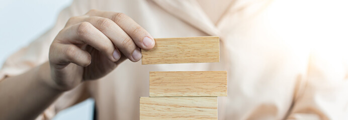 Arrange the wooden blocks into steps, higher the marketing strategy the more effort is required, Driving business at the peak concept.