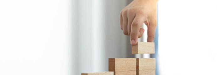 Arrange the wooden blocks into steps, higher the marketing strategy the more effort is required, Driving business at the peak concept.