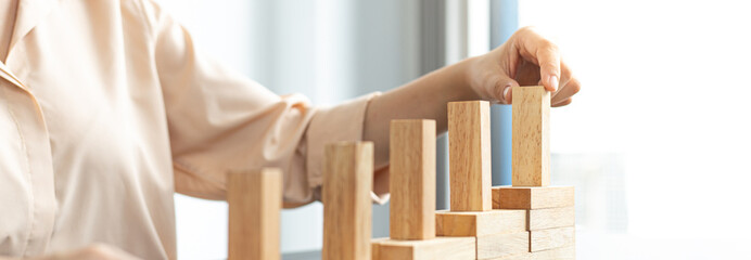 Arrange the wooden blocks into steps, higher the marketing strategy the more effort is required, Driving business at the peak concept.