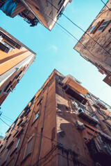 9 april 2022, Naples, Italy. A walk in the picturesque narrow alleys of the Spanish Neighborhood (Quartieri Spagnoli), the heart and soul of Naples, looking up at the sky between the buildings.