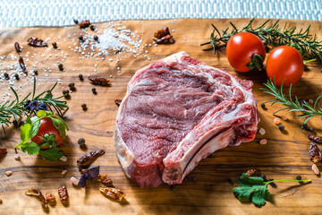 Raw steak on the bone on a wooden surface