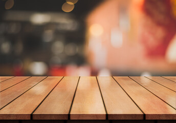 Empty wooden table top with lights bokeh on blur restaurant background.	
