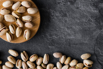 
Pistachio nuts i on dark background. Top view. Copy space.