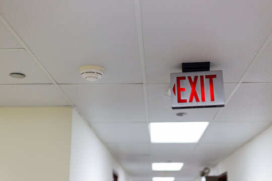 red emergency exit sign in the dark room. illuminated office exit sign.