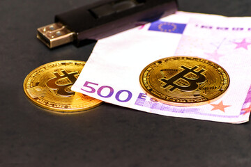 Bitcoin, euro banknote and usb flash drive on a gray table.
