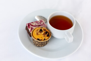  cup of tea with cake on white tablecloth