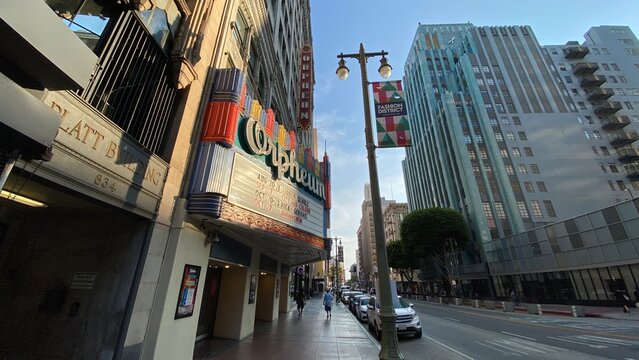 LOS ANGELES, CA, JUL 2021: Orpheum Theater in Downtown with late afternoon sunlight on the marquee and people walking past on sidewalk