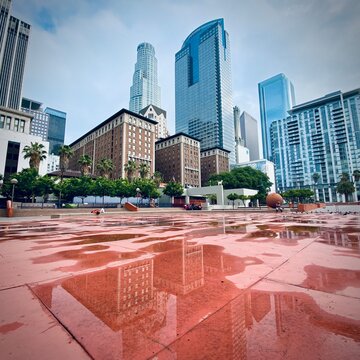 LOS ANGELES, CA, JUL 2021: view of The Biltmore Hotel and surrounding buildings with reflections, seen from Pershing Square, Downtown, after rain. Square crop