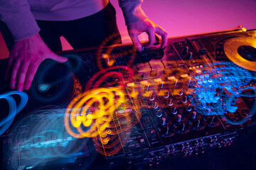 Close-up image of male hands, dj making sounds at night club party with professional sound mixer