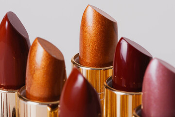 extreme close up photography of lipsticks of different colors with a gold base on white background